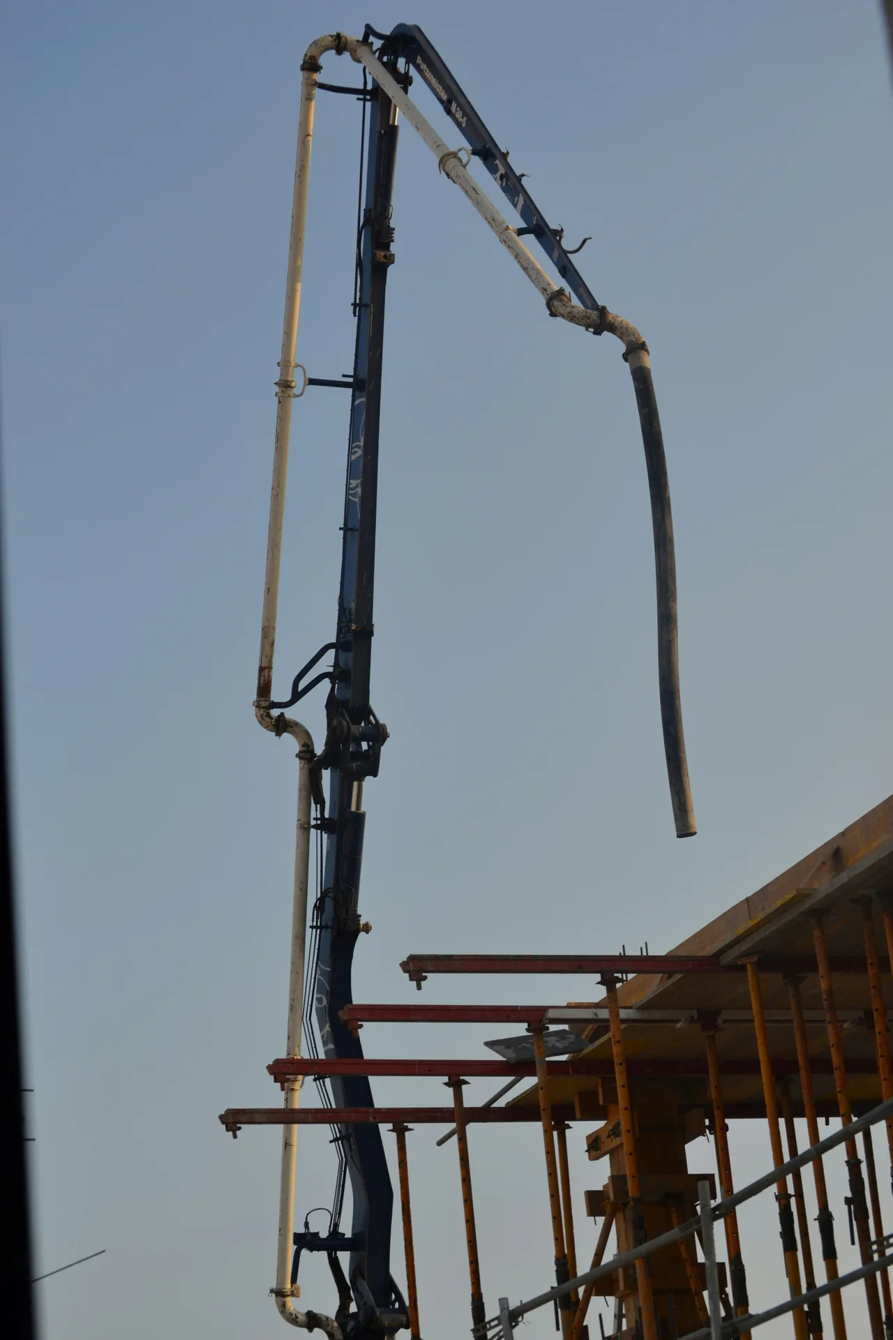 boom pump extending to second-storey deck for concrete placement