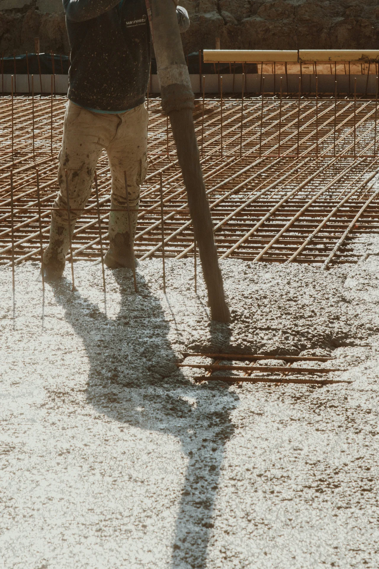 concrete pump hose placing concrete over a Portland rebar mat